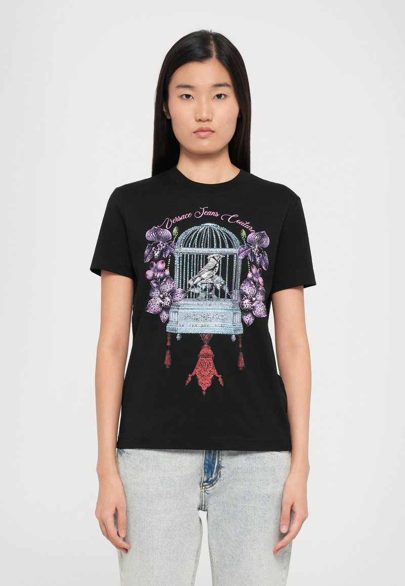 Black cotton t-shirt featuring a colorful graphic design of a birdcage with flowers and tassels. Crew neck and short sleeves.