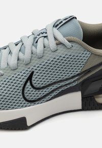 Light blue mesh athletic shoe with gray accents, black swoosh logo, textured overlays, and a cushioned sole for comfort.