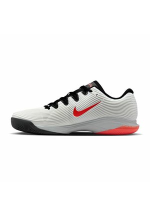 Weiße Sportschuhe mit strukturiertem Obermaterial, schwarzen Akzenten und einem roten Nike-Swoosh. Die Außensohle verfügt über ein strukturiertes Profil für Grip und Trittfestigkeit.