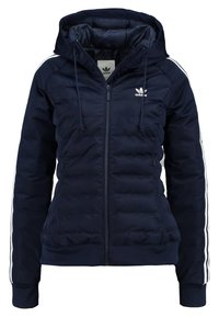 Námořnická puffer bunda se zapínáním na zip, kapucí a bílými bočními pruhy. Má prošívanou texturu a elastické manžety. Logo Adidas na prsou.