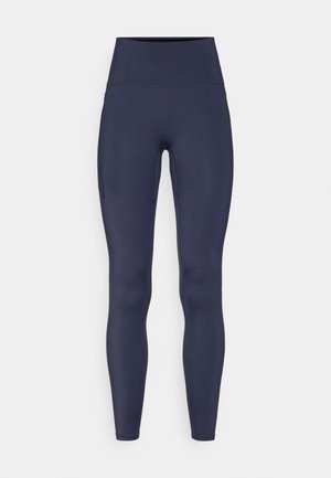 Marineblå leggings laget av elastisk stoff, med høy midje og en sidelomme. Jevn tekstur med en tettsittende design.