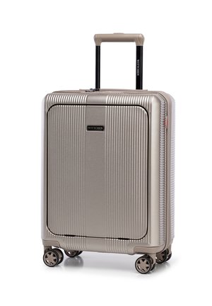 Valigia rigida di colore oro metallizzato con texture a righe verticali, manico retrattile e quattro ruote per una mobilità fluida.