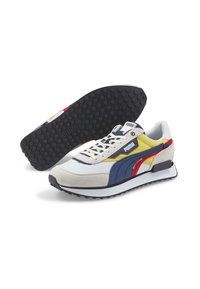 PUMA-sneakers i vitt, blått, gult och röd. Ovandel i mocka och mesh, texturerad gummisula med prickar, med snörning och en logopatch.