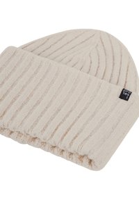 Cream beanie made of soft, textured knit fabric. Features vertical ribbed pattern and a folded cuff. Small black brand label visible.