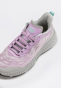 Scarpa da atletica viola chiaro con tomaia in maglia testurizzata, dettagli grigi e motivo ondulato. Presenta un colletto imbottito e una suola flessibile.