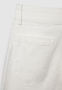 Jeans in denim bianco con un design su tasca posteriore. Il tessuto ha una texture liscia e dettagli di cuciture sottili, con una vestibilità classica.