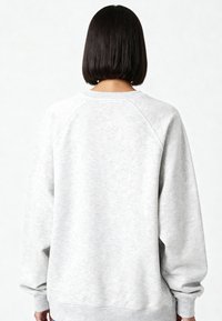 Felpa grigio chiaro con scollo rotondo, polsini a costine e vestibilità comoda. Presenta un tessuto morbido e strutturato e maniche raglan.