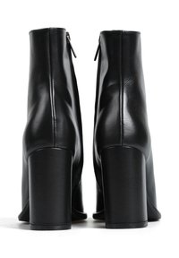 Czarne skórzane botki za kostkę o gładkim wykończeniu, z suwakiem z tyłu i grubym wysokim obcasem.