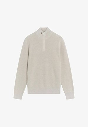 Vaaleanbeige, ribistetty neulepusero, jossa on puolivetoketju kauluksessa. Pitkät hihat, minimaalinen muotoilu, pehmeä rakenne, täydellinen kerrospukeutumiseen viileämmässä säässä.