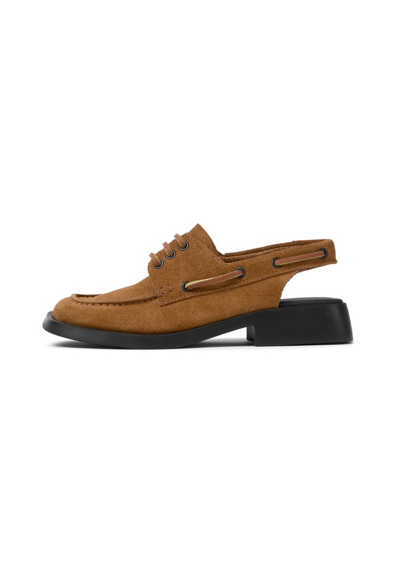 Zapato de ante marrón con diseño de slingback, puntera redonda y tacón bajo negro. Presenta cordones decorativos y recortes laterales para mayor transpirabilidad.