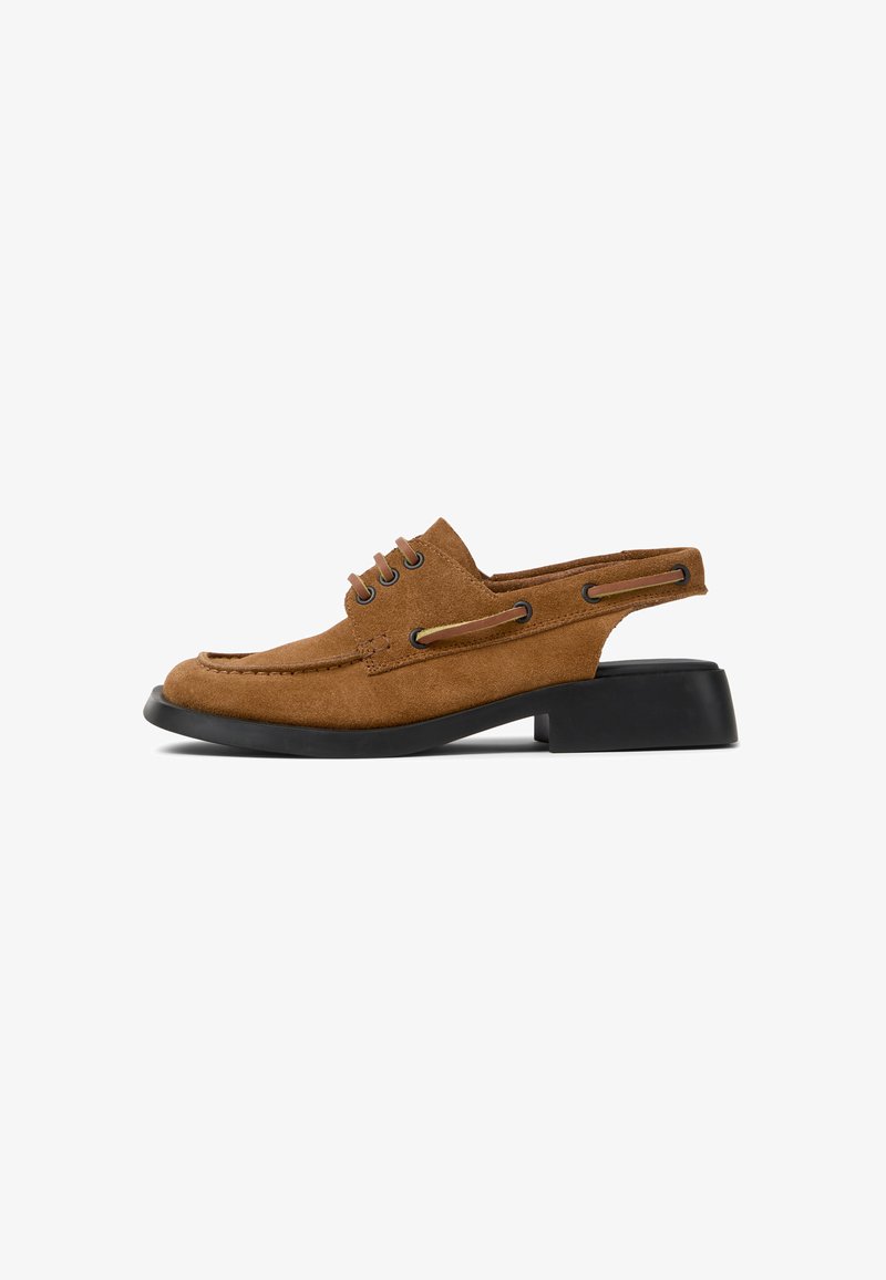 Zapato de ante marrón con diseño de slingback, puntera redonda y tacón bajo negro. Presenta cordones decorativos y recortes laterales para mayor transpirabilidad.