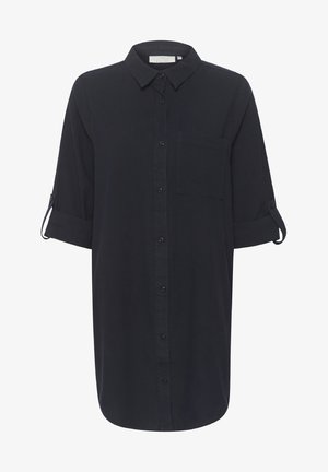 Nööpidega särk tumesinises ühtlases kangas, millel on krae, üks rinnakott ja üleskeeratud varrukad. Sile tekstuur.