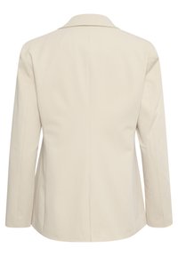Blazer beige avec un col à revers, des manches longues et une coupe ajustée. Présente des lignes épurées et une texture lisse sans fermetures visibles.