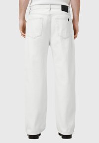 Hvide denimbukser med en afslappet pasform, der har to baglommer og en sort taljeakcent. Glat tekstur og lige ben-design.