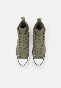 Baskets montantes en cuir vert olive avec un embout en caoutchouc blanc, un design de laçage assorti et une languette en boucle au talon.