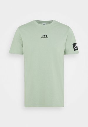 Jasnozielony T-shirt z krótkim rękawem i okrągłym dekoltem, logo Helly Hansen na środku klatki piersiowej oraz czarna naszywka z logo na lewym rękawie.