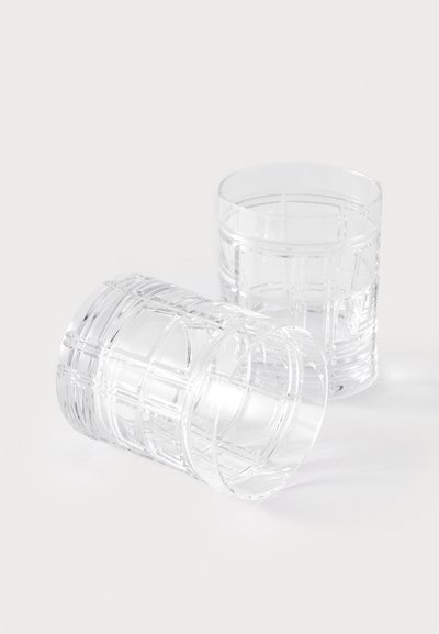 Divas caurspīdīgas stikla glāzes ar strukturētu horizontālu līniju rakstu. Viena glāze ir vertikāla, otra ieteikta.