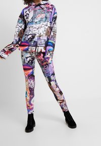 Hoodie och leggings-set med livfulla grafiska tryck i lila, rosa och svart. Tillverkat av ett stretchigt, slätt tyg.