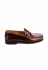 Mocasín de cuero marrón con un diseño superior cosido, punta en forma de almendra y un bajo tacón de goma negra. Acabado suave con acentos decorativos.