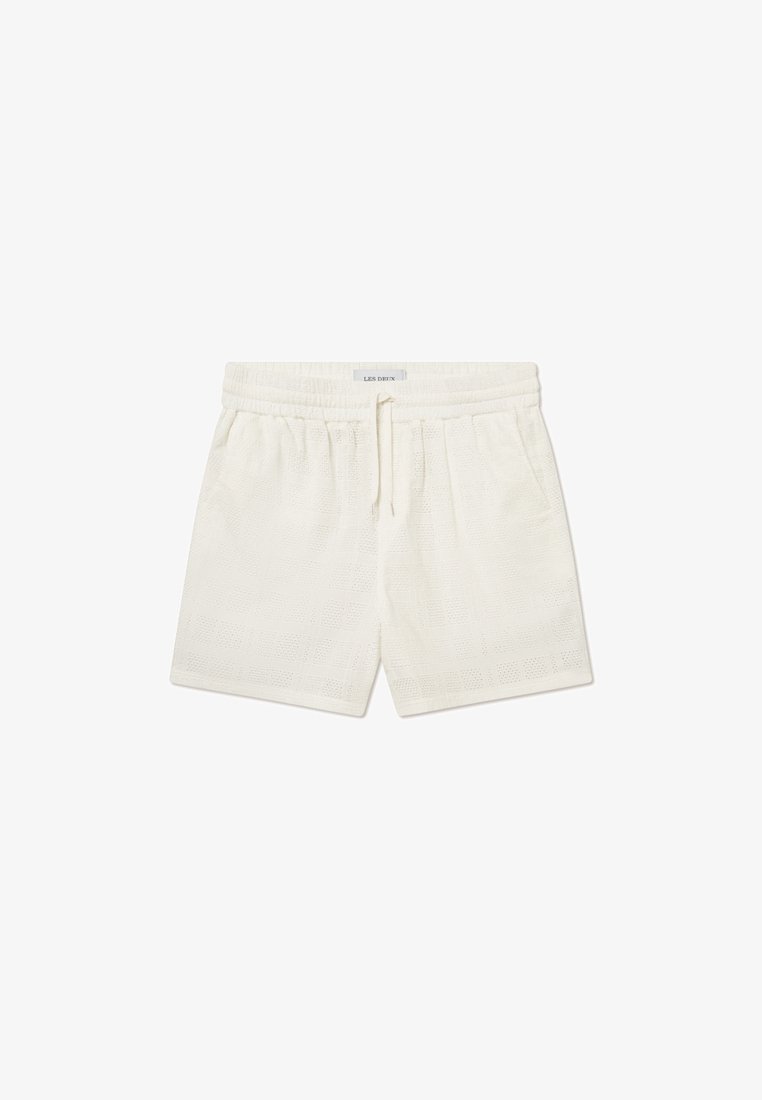 Shorts blancs en tissu texturé avec une taille élastique et un cordon de serrage. Le design présente un motif en grille avec des découpes discrètes.