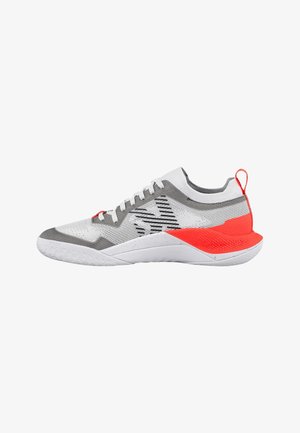 Zapatilla deportiva blanca y gris con talón y lengüeta de tira en naranja, parte superior de malla, cierre de cordones y suela con diseño.