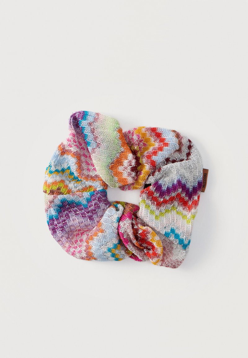 Chouchou tricoté multicolore avec motif chevron dans des tons de violet, orange, rose, vert, bleu et blanc sur fond uni.
