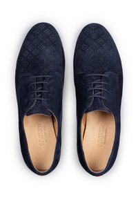 Scarpe in suede blu scuro con design superiore perforato, chiusura con lacci e plantare in pelle liscia. Forma complessivamente elegante e accenti minimi.