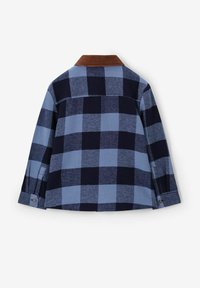 Flanellen overhemd in een marineblauw en lichtblauw ruitpatroon, met een bruine corduroy kraag. Beschikt over een rugpand en knoopaccenten op de mouwen.