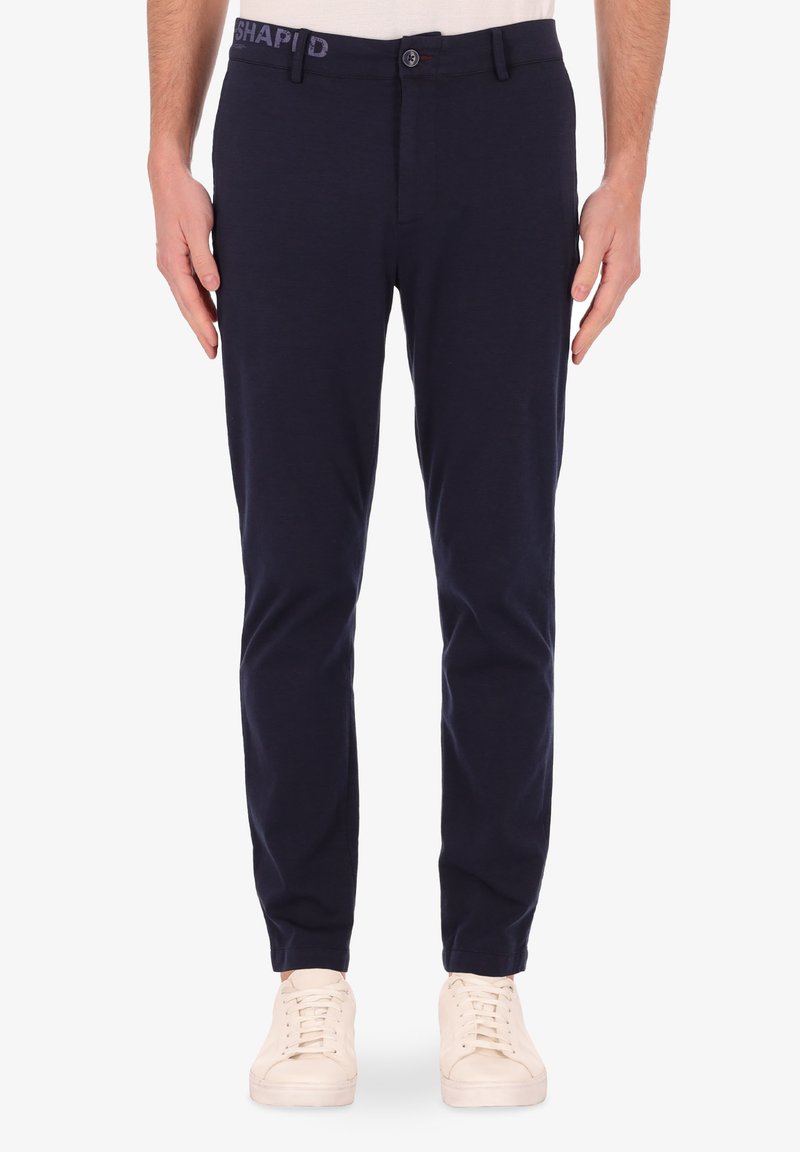 Pantaloni di cotone blu navy con vestibilità slim, chiusura a bottone e ricamo "SHAPED" sulla vita. Presenta tasche laterali e posteriori standard.