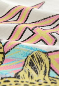 White fabric with vibrant graphic print featuring yellow, pink, and blue colors. Includes abstract shapes and textured detailing.