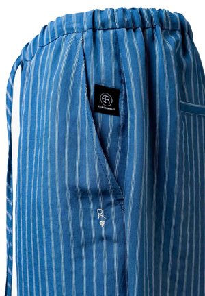 Blauwe stof met witte verticale strepen met een zijzak, elastische tailleband en een zwart label met het witte "Elias Rumelis" logo.