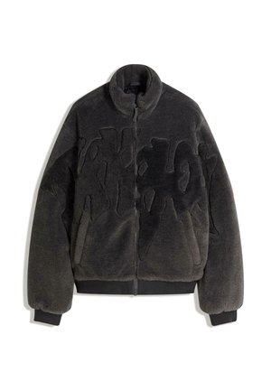 Černá bunda z umělého kožíšku s vysokým límcem, zapínáním na zip a prošitým vzorem na přední straně, s žebrovanými lemy na rukávech a spodním okraji.