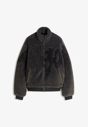 Černá bunda z umělého kožíšku s vysokým límcem, zapínáním na zip a prošitým vzorem na přední straně, s žebrovanými lemy na rukávech a spodním okraji.