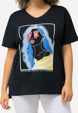 T-shirt noir avec un portrait abstrait coloré d'une femme aux cheveux bleus, des fleurs rouges sur les yeux, des lèvres rouges et le texte « Positive vibes and a soul full of sunshine. »