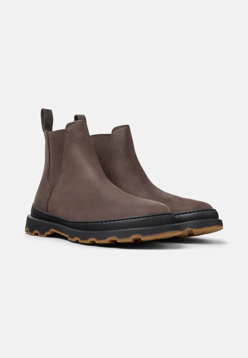 Bottines Chelsea en cuir brun avec des panneaux latéraux élastiques, semelle intermédiaire noire et semelle extérieure en caoutchouc présentant un motif texturé.