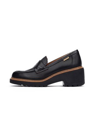 Mocassino in pelle nera con superficie strutturata, punta arrotondata e suola spessa. Presenta suola a zigzag e cuciture decorative sulla tomaia.