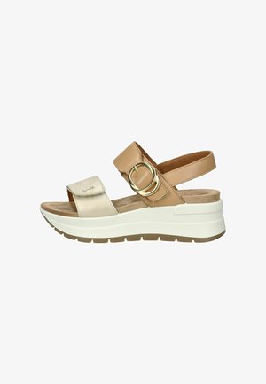 Sandalo scivoloso in tan e metallizzato con accentuazione a fibbia, soletta imbottita e suola bianca. Presenta una morbida cinghia e un retro aperto per una facile indossabilità.