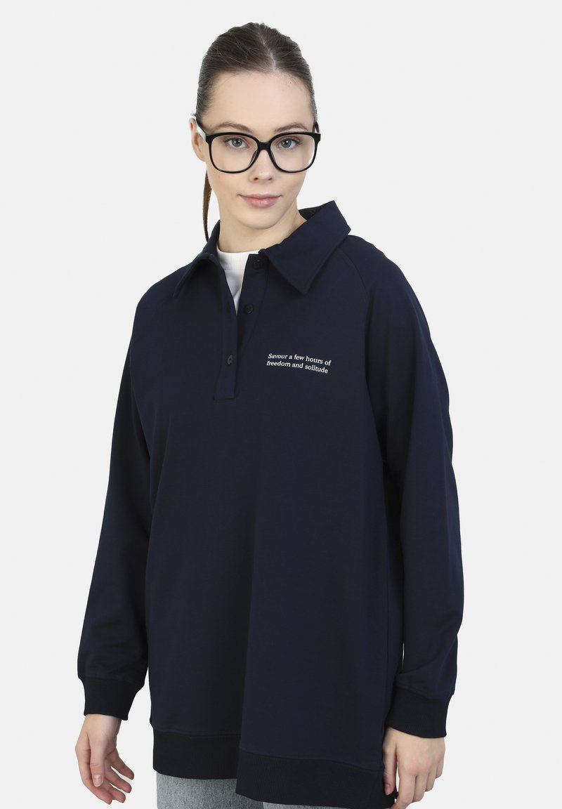 Polo a maniche lunghe blu navy con colletto, caratterizzato da un testo ricamato sul petto, realizzato in tessuto morbido con polsini a costine.