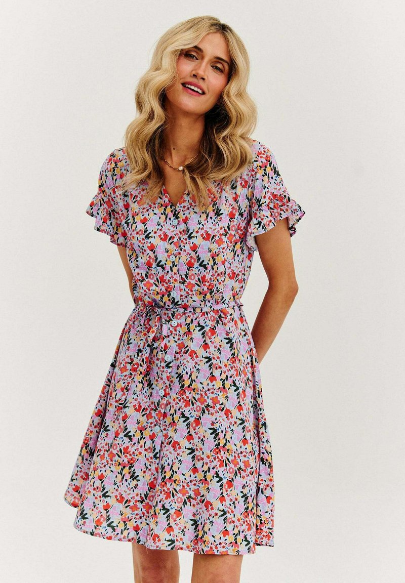 Kwiatowa sukienka z krótkimi falbankowymi rękawami, dopasowanym stanem i kolorowymi kwiatami na jasnym tle. Lekka tkanina o swobodnym kroju.