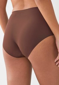 Bruine hoge tailleonderbroek gemaakt van gladde stof, met een naadloos ontwerp, een zachte tailleband en een gematigde bedekking. Geen zichtbare patronen.