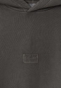 Sudadera gris hecha de tela texturizada, con un parche de marca en el frente que lleva el texto "Pepe Jeans". Capucha delgada y bordes acanalados.