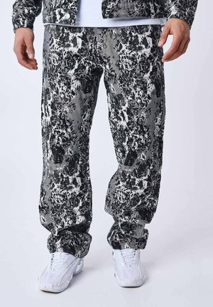 Sorte og hvide mønstrede bukser lavet af denim med en løs pasform, der har en struktureret overflade og knaplukning i taljen.