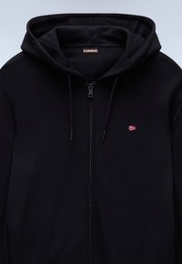 Crna majica s kapuljačom na patentni zatvarač, izrađena od mekanog materijala. Ima prednji patentni zatvarač, podesivu kapuljaču s pertlama i mali vezani detalj norveške zastave.