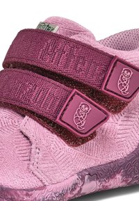 Chaussure enfant rose avec tissu texturé, deux brides réglables en rose foncé et une semelle en caoutchouc à motifs avec des accents de logo animal.