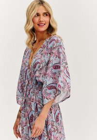 Dlhé, voľné šaty s výstrihom do V, elastickým pásom a paisley vzorom v odtieňoch modrej, ružovej a čiernej. Ľahký, jemný materiál.