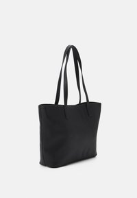 Musta olkalaukku, jossa on kaksi pitkää kantohihnaa, valmistettu sileästä ja kestävästä materiaalista. Suorakulmainen muoto minimalistisella muotoilulla, ilman näkyvää varustelua tai yksityiskohtia.