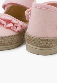 Růžové plátěné espadrilky s rýhovaným akcentem, tkaným jutovým lemem a béžovou gumovou podrážkou. Nastavitelný pásek v oblasti kotníku.