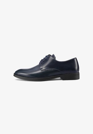 Scarpa elegante in pelle blu navy con finitura liscia, punta arrotondata e design con lacci. Presenta un sottile dettaglio cucito e una suola sottile in gomma.