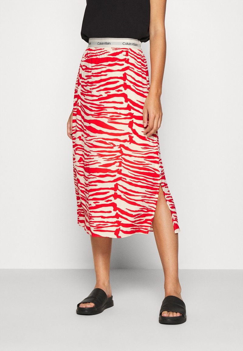 Röd och creamrandig midi-kjol med sidofickor och elastisk linning med Calvin Klein-logotyp. Bärs med svarta slide-sandaler.