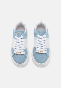 Baskets en daim bleu clair avec une semelle intermédiaire blanche, des lacets blancs et un accent en métal doré à double anneau sur une bande blanche traversant le haut.